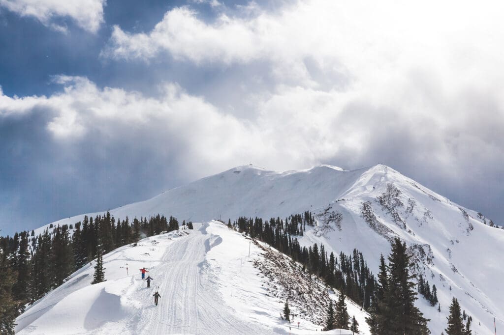 skiers hiking up the aspen highlands bowl