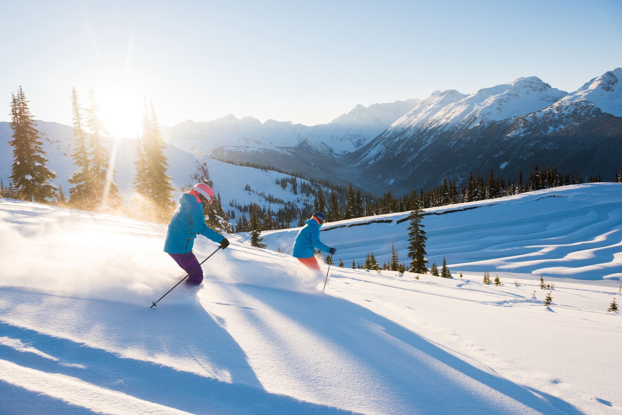 Couple skiing on a sunny powder day