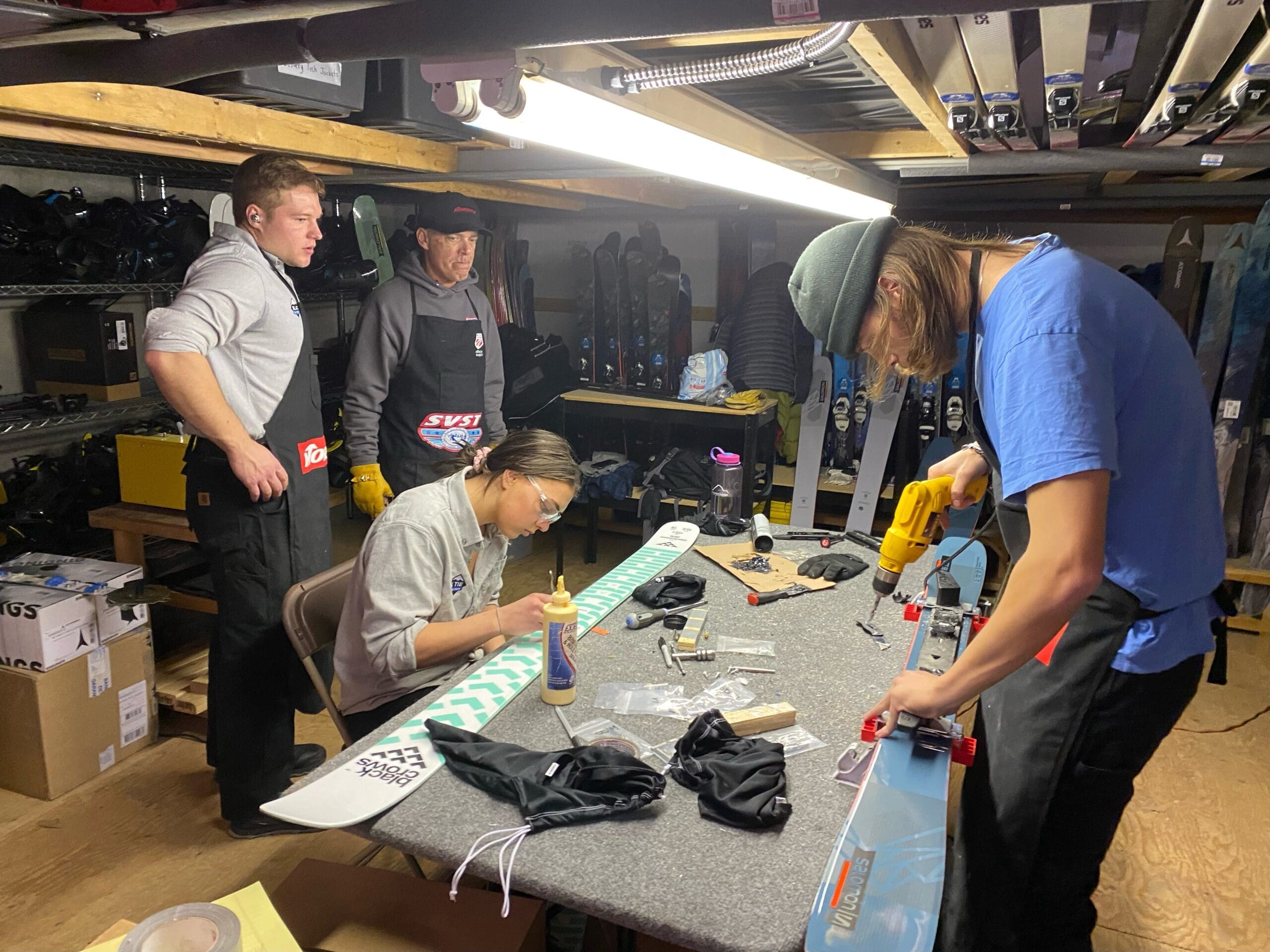 black tie ski rental technician installing bindings on skis