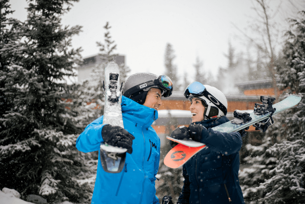 Happy skiing couple smiling at each other