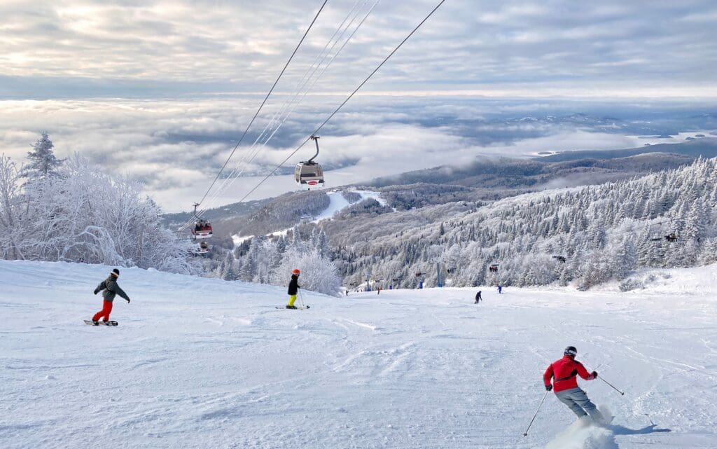Mont and Tremblant Lake in winter with skiers on the foreground, Quebec, Canada